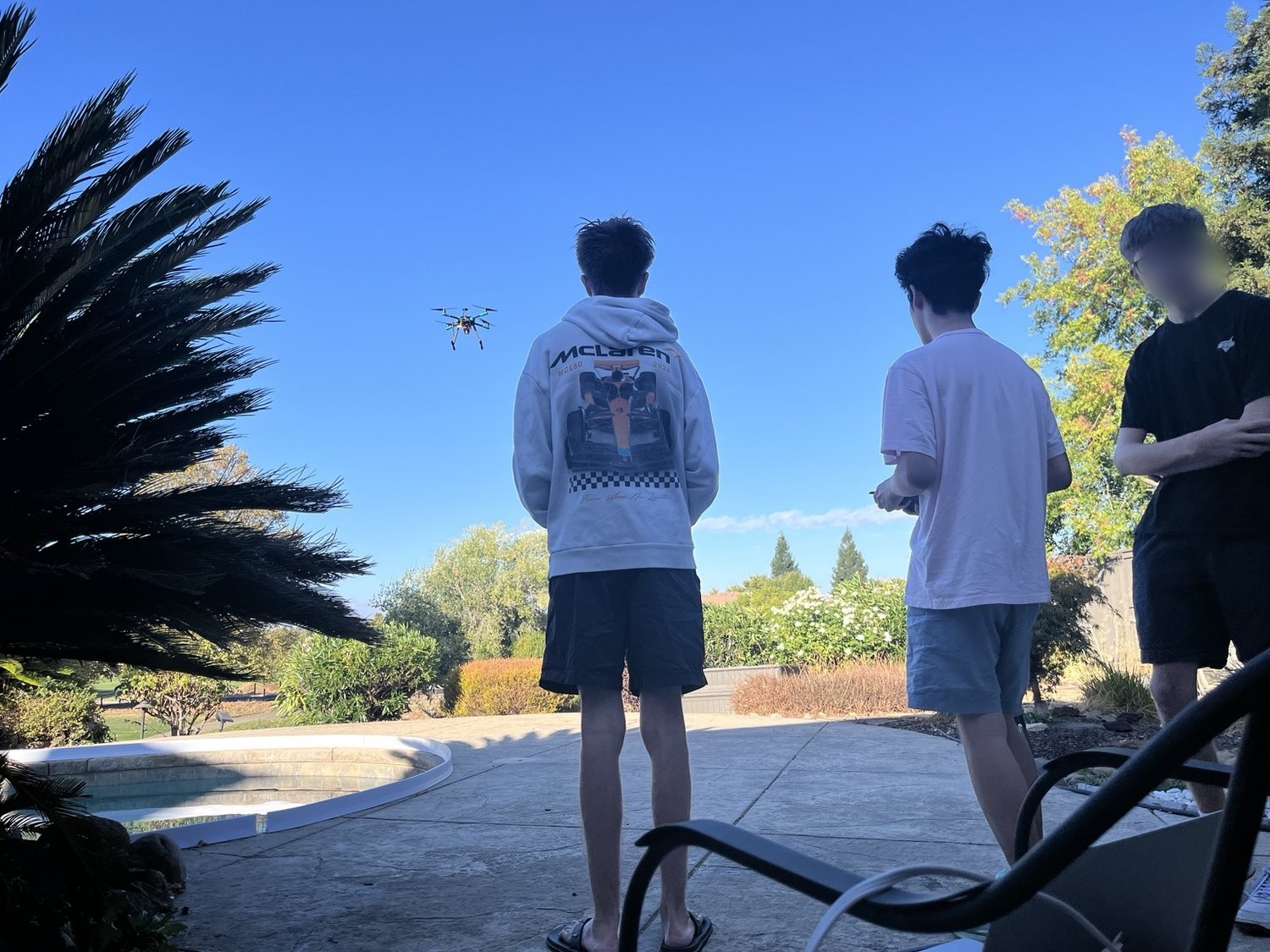 Students outdoors watching a drone in flight during a technology session